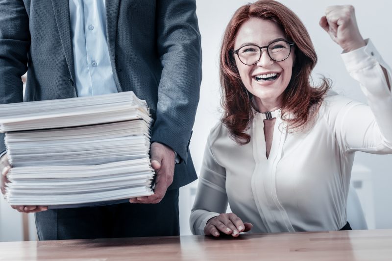 Radiant woman getting excited after checking pile of document